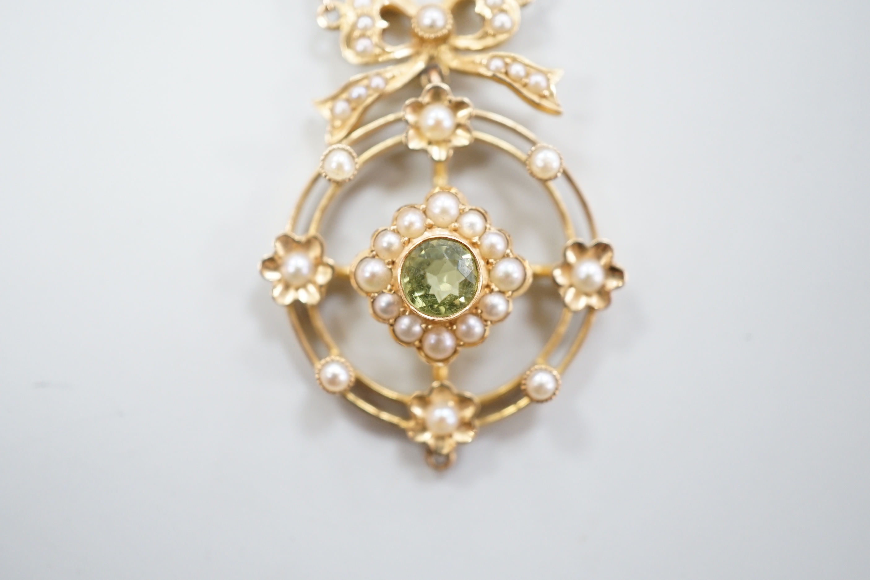 An Edwardian yellow metal, peridot and seed pearl cluster set pendant necklace, overall 55cm, gross weight 5.7 grams.